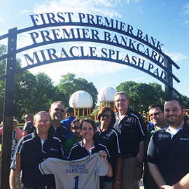 First PREMIER Bank - PREMIER Bankcard Splash Pad sign with people standing in front 