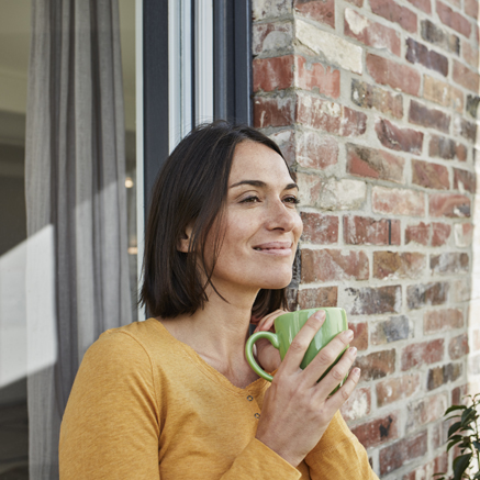 woman standing outside drinking coffee