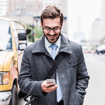 business man on busy street looking at phone