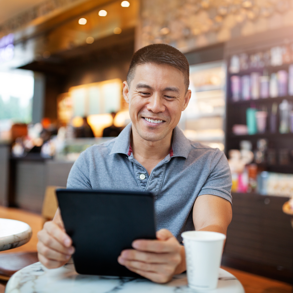 Man on tablet in cafe